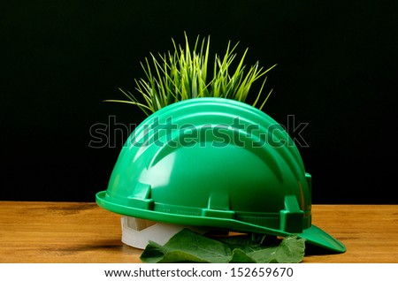 Green grass and green helmet- environmental friendly industry concept