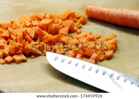 carrots cut  and kitchen knife on wooden plank