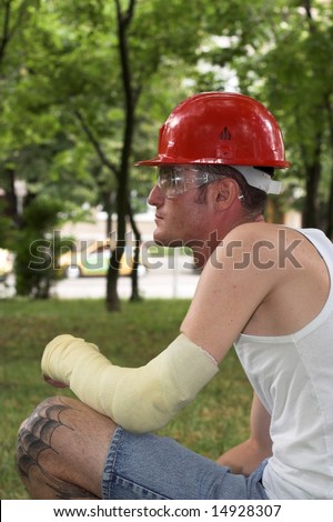 tattooed man with red helmet and hand in plaster