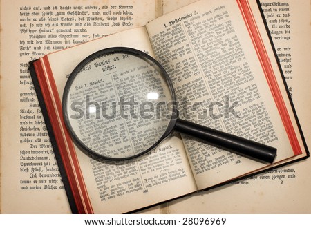 old books and magnifying glass close up