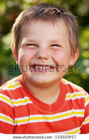 Boy with a smile on his face in an orange striped shirt
