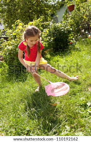 Girl with a pink butterfly net catching butterflies