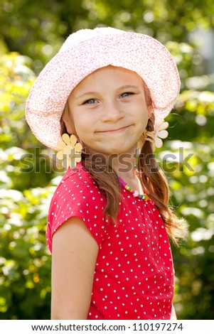 Smiling girl with pigtails in a summer white panama