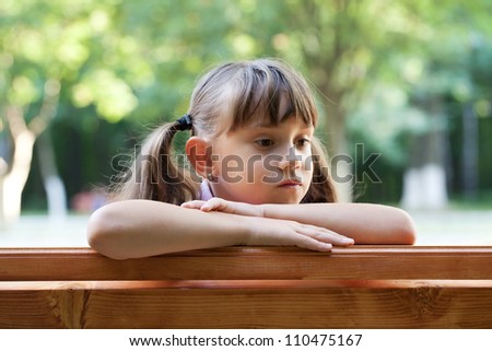 Little girl sits and thinks about something