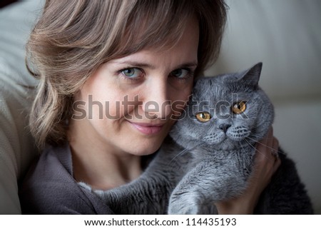 Pretty young woman with a cat in her arms