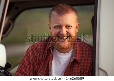 Cheerful red-bearded man in a red plaid shirt