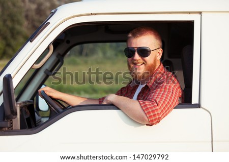 Cheerful driver of a small pickup truck