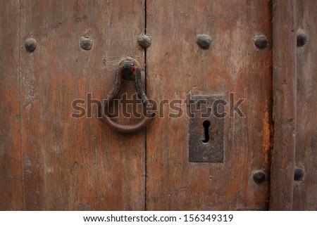 Fragment of old wooden door with rusty handle