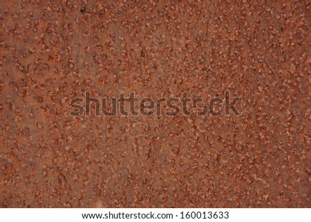 Brown metal surface is pitted with rust