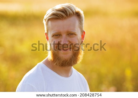 Smiling young man with a big red beard