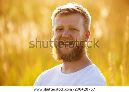 Cheerful young man with a big red beard