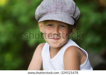Portrait of charming fair-haired boy in a gray cap