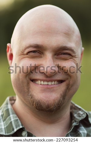 Happy smiling bald man in a plaid shirt