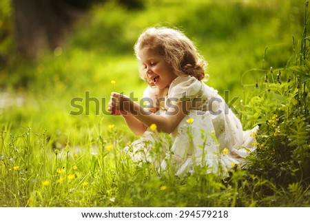 Funny happy little girl with a yellow flower