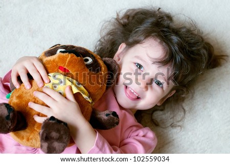 Adorable little girl is hugging big teddy bear