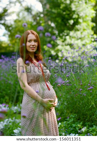 Portrait of a pregnant woman in third trimester relaxing in park
