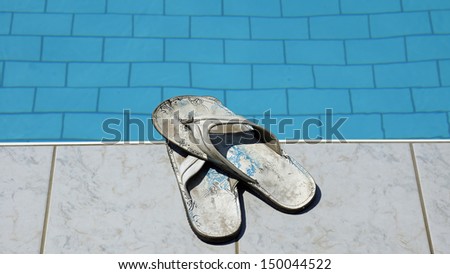 Used men white flip flops at a pool