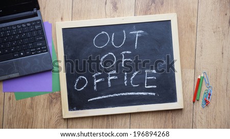 Out of office written on a chalkboard at the office