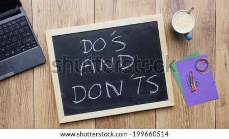 Do\'s and don\'ts written on a chalkboard at the office
