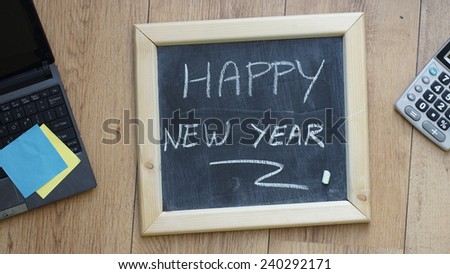 Happy new year written on a chalkboard at the office