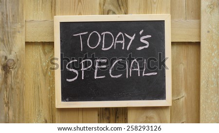 Today\'s special written on a chalkboard hanging at a wooden wall