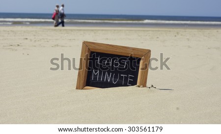 Last minute written on a chalkboard at the beach