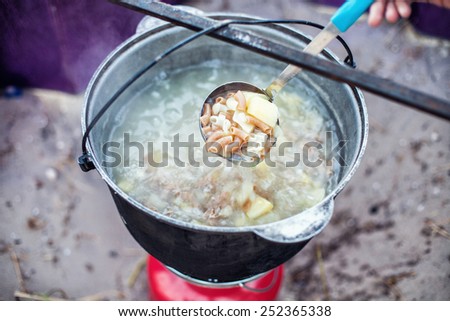 Soup cooking on the nature in a big pot