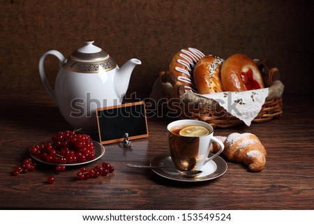 Still-life with a fresh batch fragrant tea and a red currant, tasty appetizing cheese cakes with fragrant fresh tea and a ripe red currant