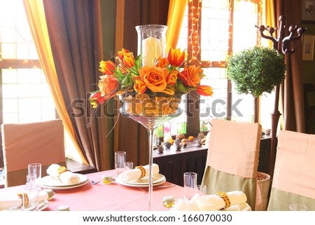Table ornament at restaurant - a beautiful bright unusual bouquet from tulips and roses and orange segments