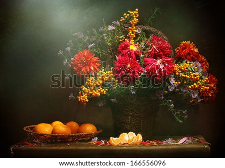 Bright magnificent fine bouquet made of autumn colours and branches of a mountain ash with juicy ripe fragrant tangerines in a wattled plate