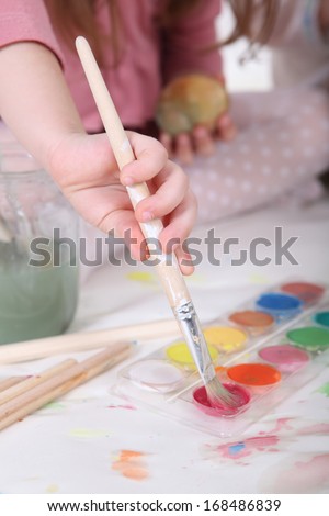 Water colour paints and brush for drawing by paints in hands of the child