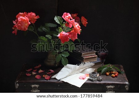 Still-life with books and a bouquet of roses, a bouquet of fine fragrant gentle roses in a beautiful copper jug and not begun novel of the writer