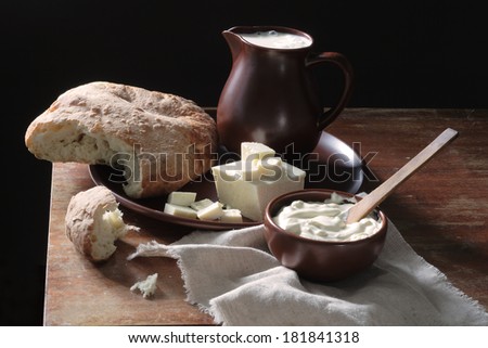 Still-life with white cheese both rural bread and sour cream, fragrant bread of a house batch and fresh milk in a clay jug both white cheese and rural tasty sour cream