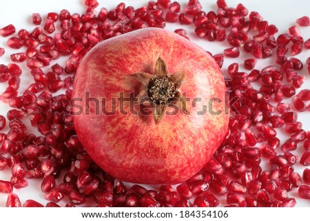 Still-life with a pomegranate, a ripe juicy red pomegranate and appetizing grains of a red pomegranate