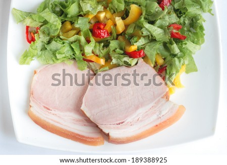 Still-life with appetizing slices of meat submitted with salad from slices of sweet yellow and red Bulgarian pepper and juicy leaves of green salad