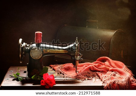 The old manual sewing-machine and bright red rose