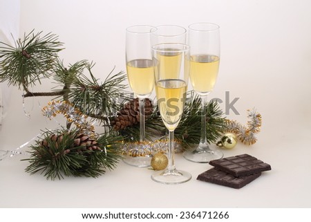 Still-life with wine glasses with champagne and gold spheres, chocolate and cones, a New Year\'s still-life