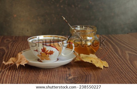 Still-life with a cup of tea, honey and autumn leaves, an autumn still-life