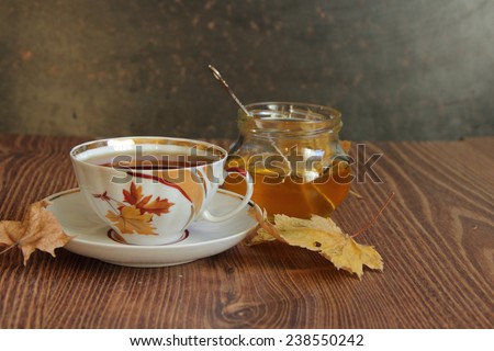 Still-life with a cup of tea, honey and autumn leaves, an autumn still-life