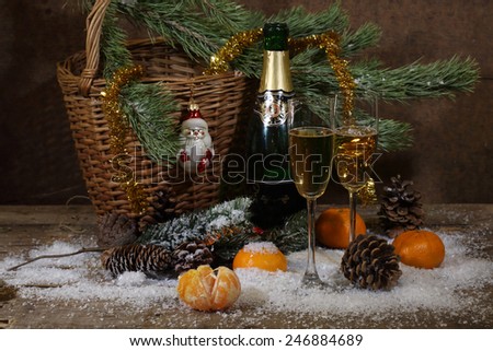 Champagne, tangerines and fur-tree branch with cones under snow