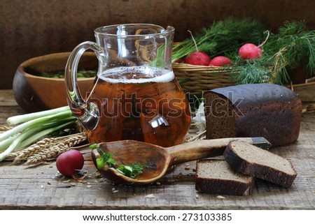 Jug with kvass and rye bread on a wooden table