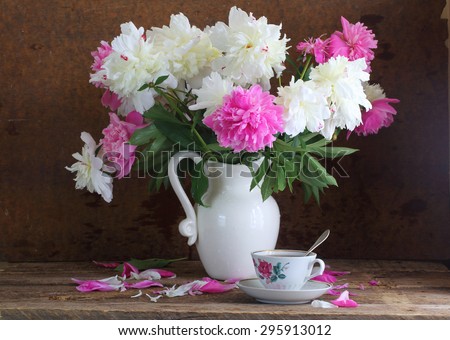 Tea and peonies, still-life with tea and a bouquet of peonies on a wooden table