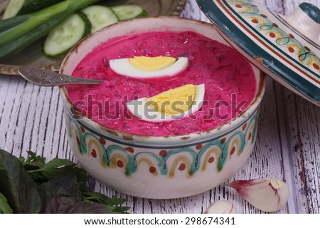 Beetroot soup - cold soup with a beet and egg submitted with parsley, a basil and a fresh cucumber