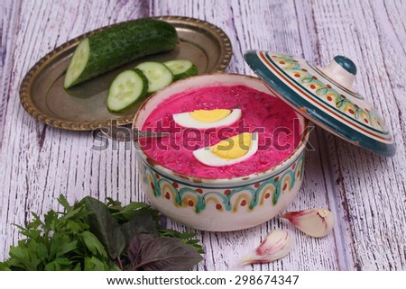 Beetroot soup - cold soup with a beet and egg submitted with parsley, a basil and a fresh cucumber