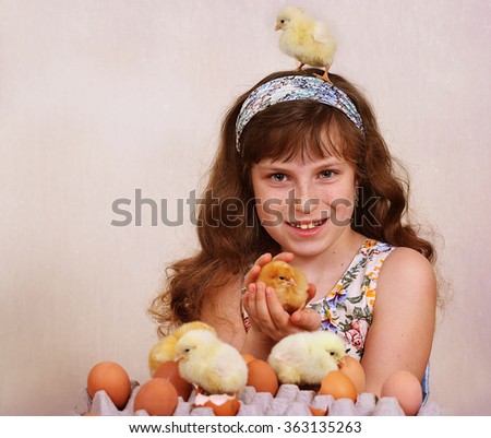 The girl plays with live small chickens