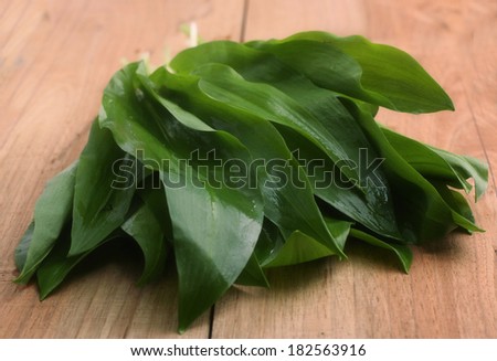 Fresh leaves of garlic on a wooden Board