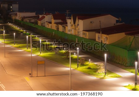 Night city Adler on the Black sea, the green lawn , lit by lanterns and slipways