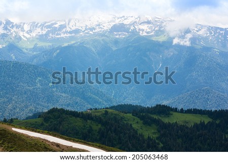 SKI RESORT ROSA KHUTOR IN THE SUMMER . MOUNTAINS OF THE NORTH CAUCASUS OVERGROWN FORESTS AND WRAPPED UP THE CLOUDS