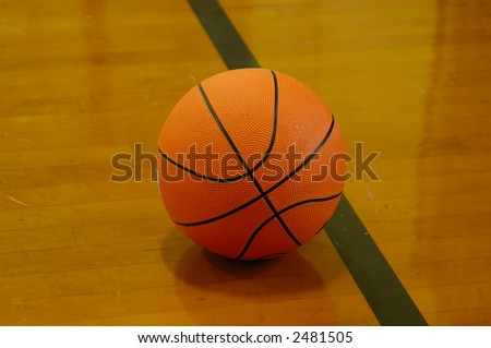 篮球球在法院- 木楼层以球的反射在木头 商业图