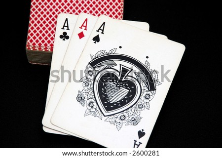 Three aces and a card deck on a black background